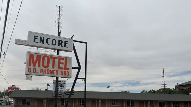Un motel con un letrero que indica que ofrece servicio telefónico D.D. y HBO.