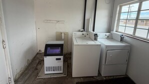 Un lavadero pequeño con lavadora, secadora y calentador de agua.