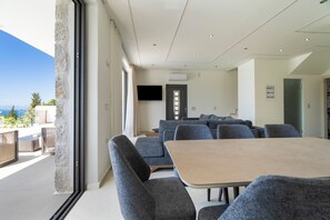 Ein modernes Interieur mit Essbereich, Sofas und einem Fernseher.