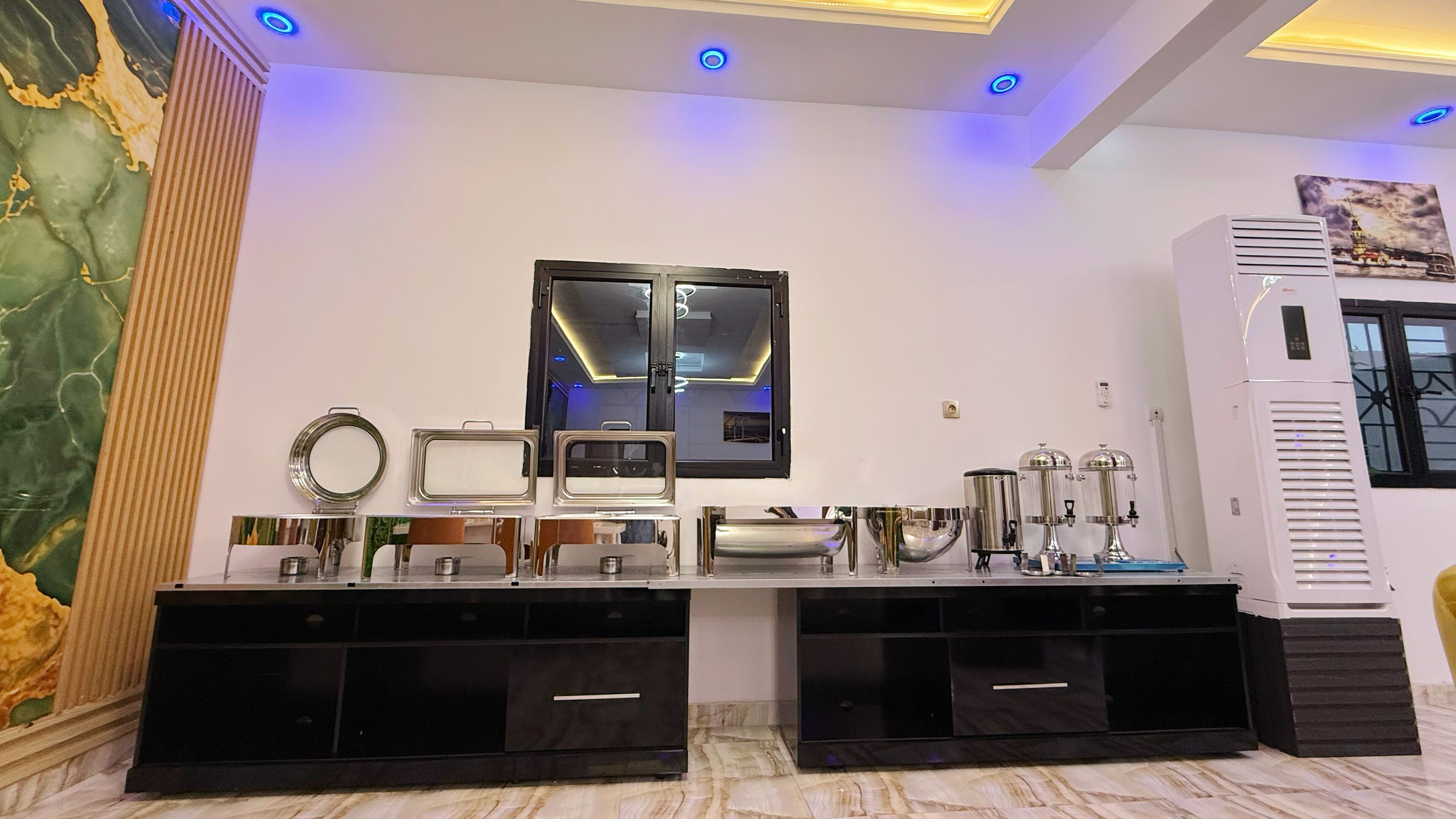 A modern kitchen with a marble backsplash, a large mirror, and built-in cabinets.