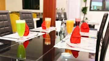 A conference table with chairs, each with a napkin holder, and glasses of various beverages.