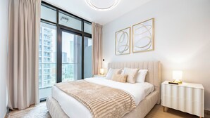 Un dormitorio moderno con una cama grande, una mesita de noche, una ventana con cortinas y arte abstracto en la pared.