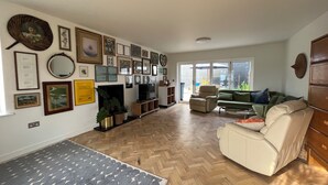 Een woonkamer met een open haard, een televisie en een bank.