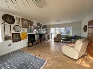 Ein Wohnzimmer mit Kamin, Fernseher und einer Couch.