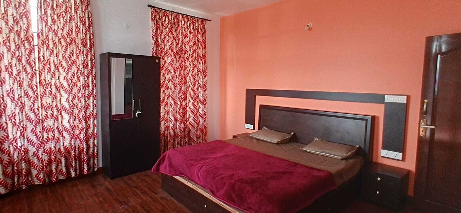 A bedroom with a bed, a wardrobe, and a door.