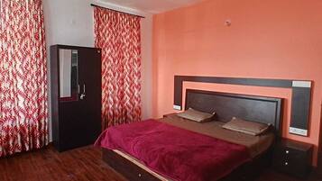 A bedroom with a bed, a wardrobe, and a door.