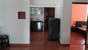 Un pasillo que conduce a una cocina con armarios, un refrigerador y un lavabo.