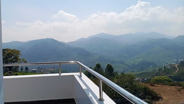Un balcón con barandilla metálica que da a un paisaje montañoso.