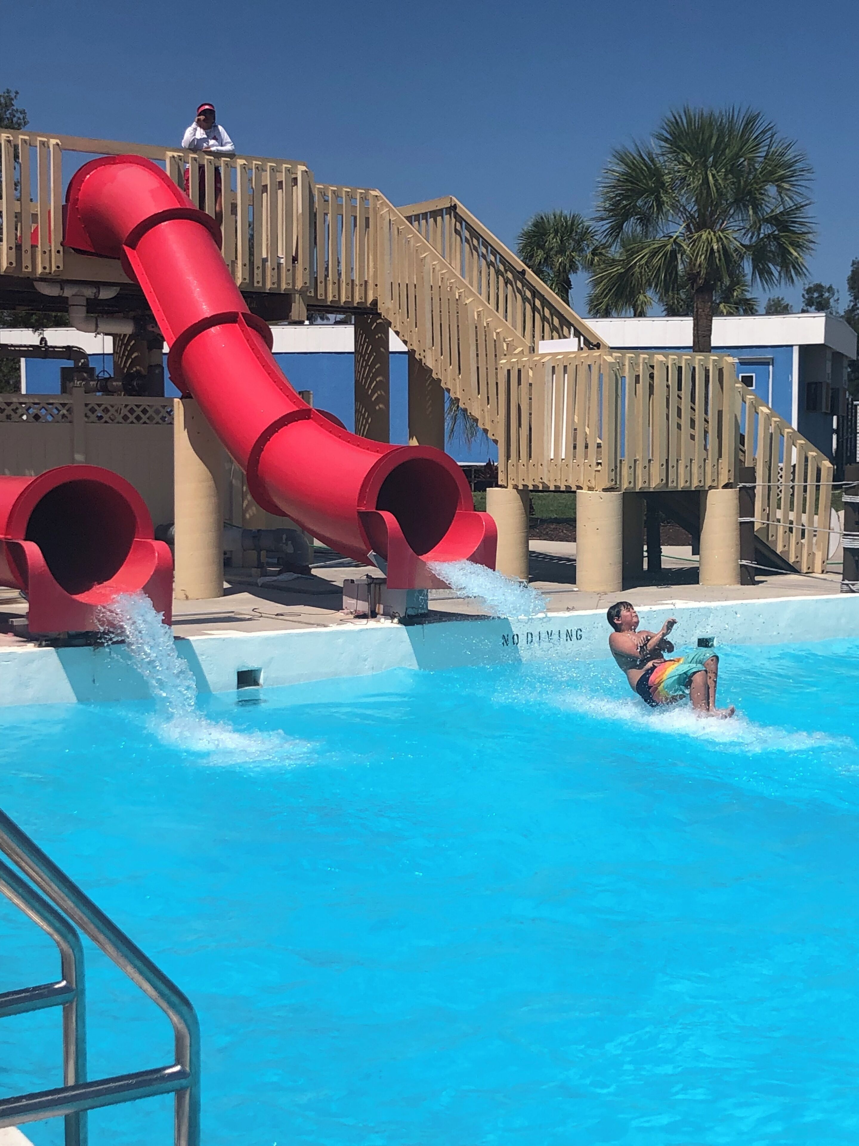 Ein Wasserpark mit einer roten Rutsche und einem Schwimmbecken.