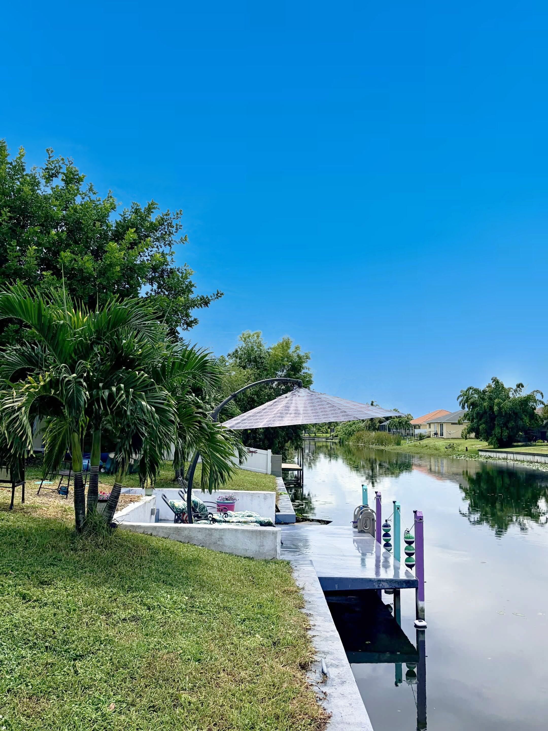A tranquil outdoor area with a water feature, a concrete pathway, and a gazebo.
