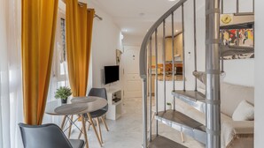 Un intérieur moderne comprenant un escalier, un coin repas et une cuisine.