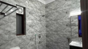 A bathroom with a toilet, a shower, a sink, and a mop. - Horizon & Hearth - Scenic Mountain View Villa (Dehradun)
