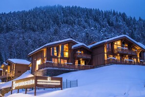 A wooden lodge with multiple balconies and a sign indicating it is a ski resort. - R Sidence Les Portes de Meg ve C614 (Praz-sur-Arly)