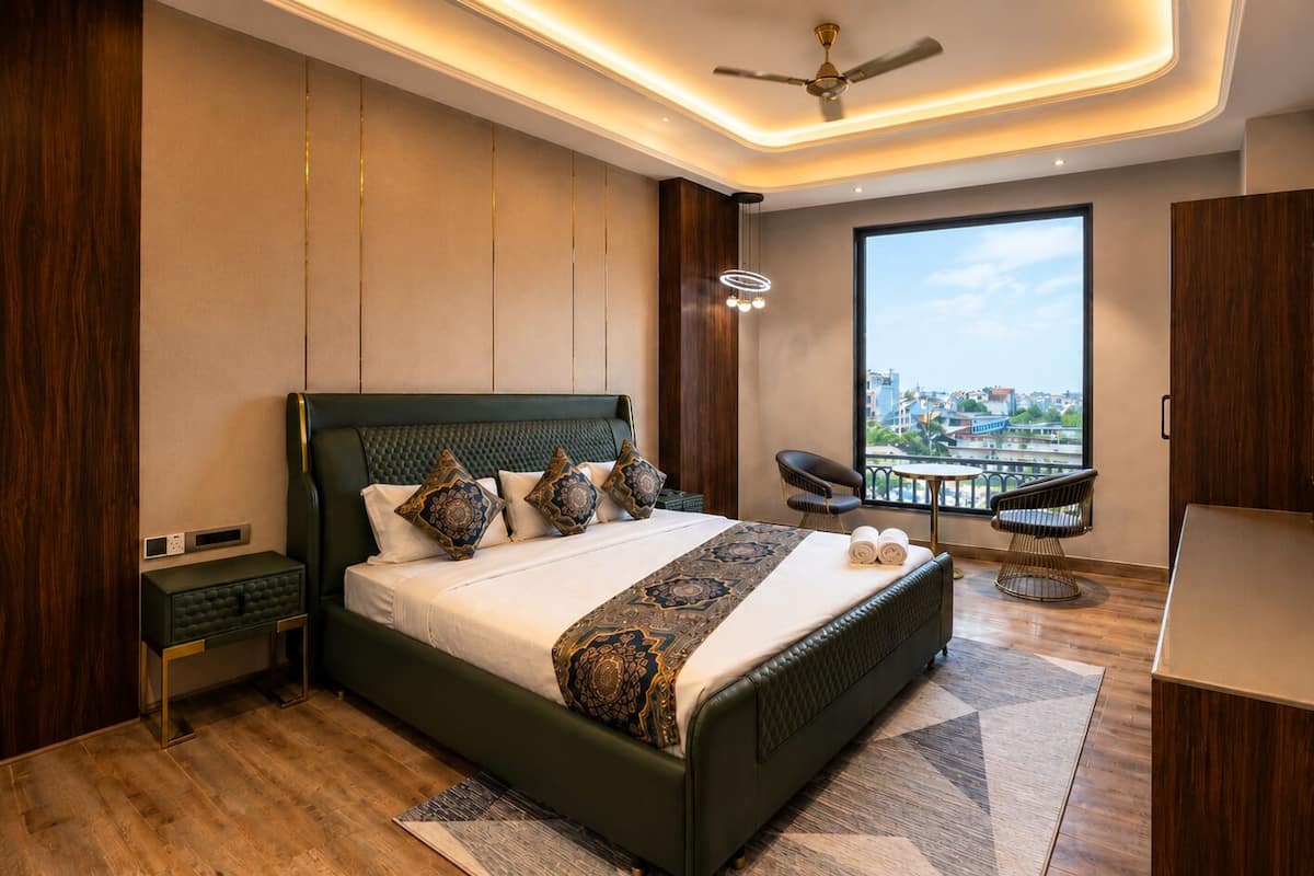 Quarto moderno com uma cama grande, televisão, vista para a varanda e ventoinha no teto.