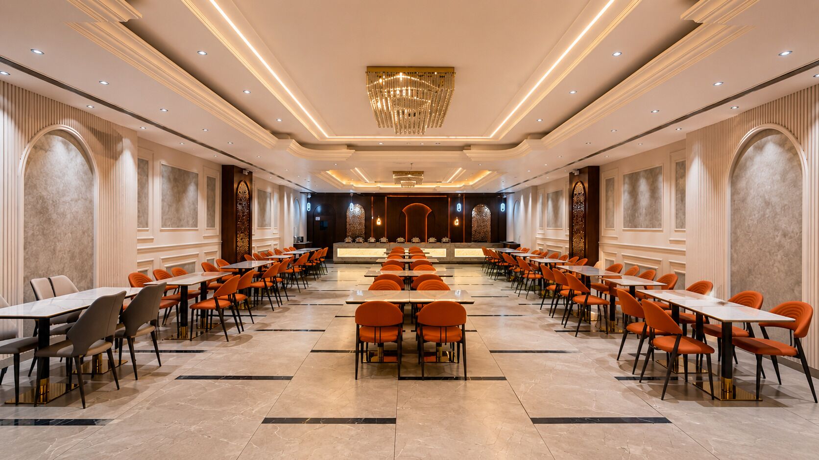 A spacious banquet hall with long tables and chairs, a central chandelier, and a marble floor.