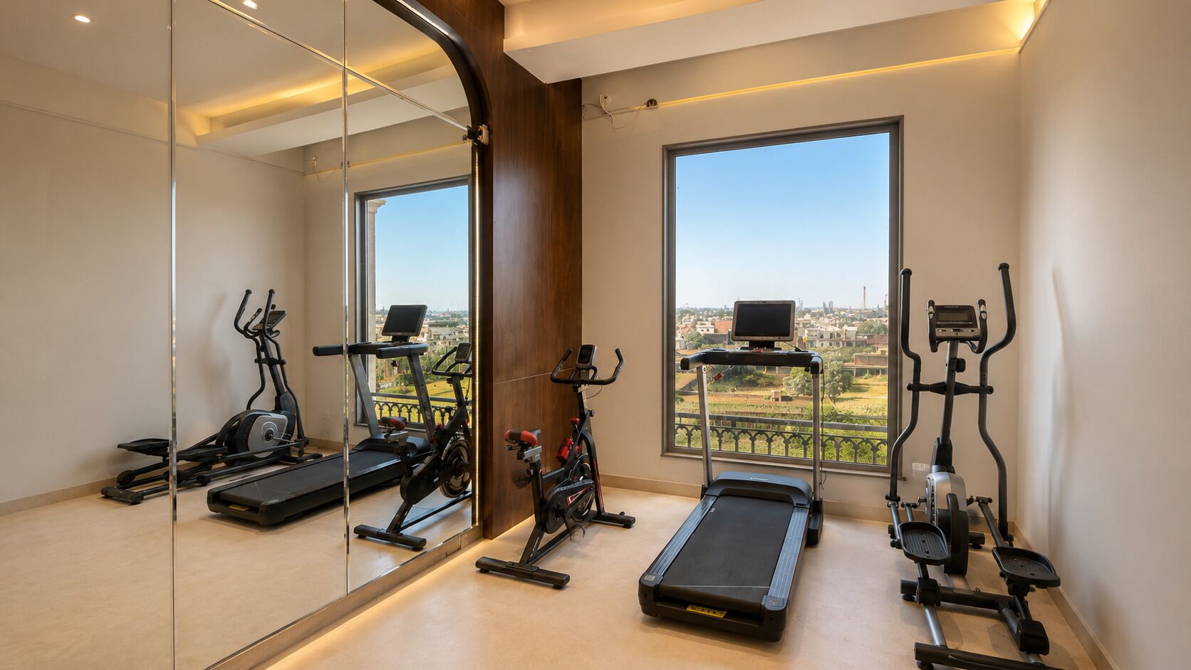 A gym with various exercise equipment, large windows, and a view of the city.