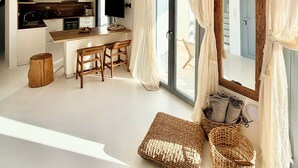 Een moderne keuken met houten balken, een eethoek met krukken, een grote spiegel en een glazen schuindeur naar een balkon.