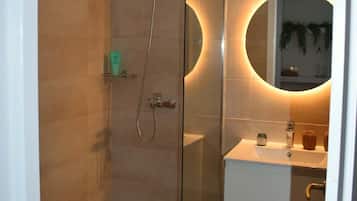 Een douche, handdoeken, zeep, toiletpapier