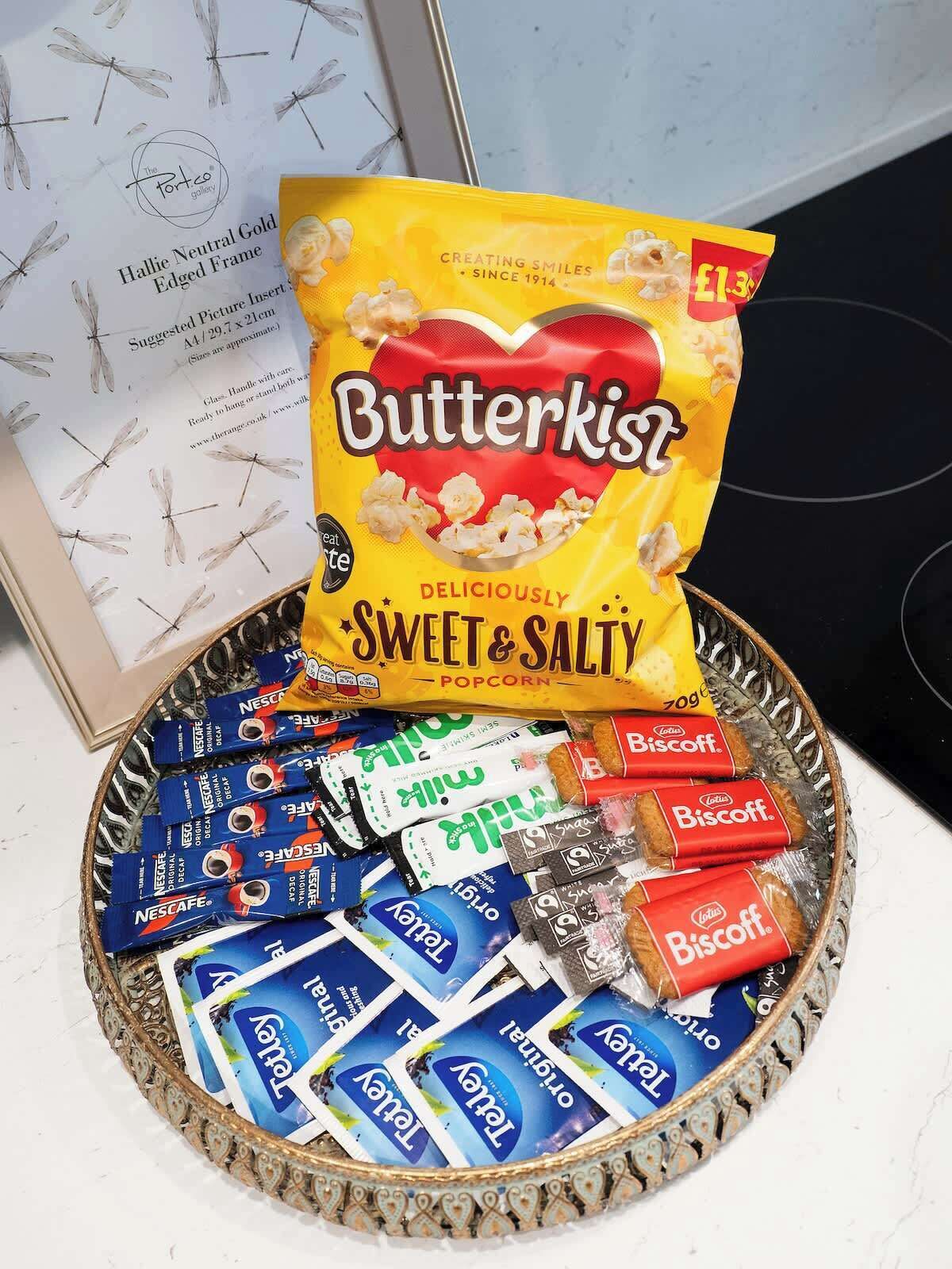 A tray with Butterkist popcorn and assorted snacks.