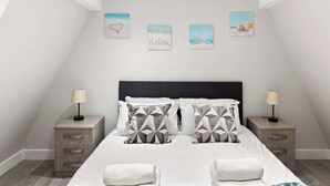 Quarto com cama, duas mesas de cabeceira e decoração na parede.