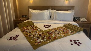 Ein Hotelzimmer mit einem Bett, zwei Nachttischen und einem an der Wand montierten Telefon.