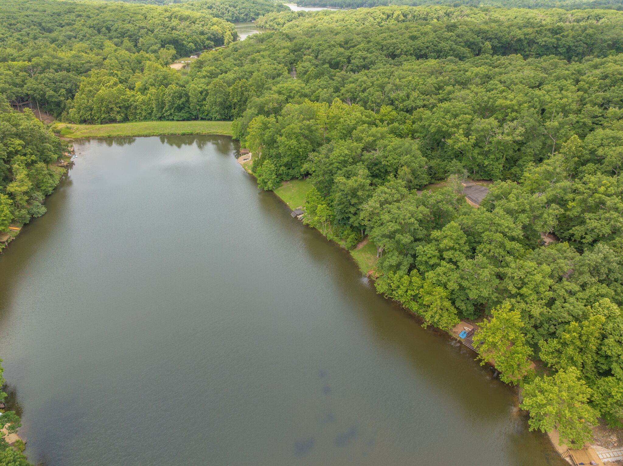 An aerial view of a lake surrounded by dense forest.