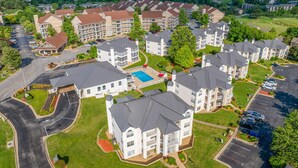 Un quartiere residenziale con edifici a più piani, una piscina e un parcheggio.