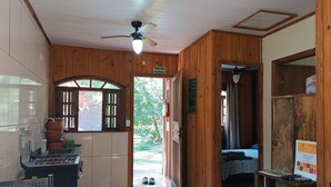 Ein Holzinnenraum mit Küche, Essbereich und Schlafzimmer.
