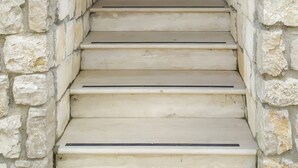 A stone-walled entrance with a brown door and a set of beige steps leading up to it. - Canterno Country House - near Fiuggi (Trivigliano)