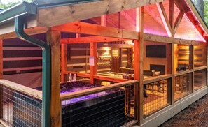 Eine Blockhütte mit Glasveranda, Whirlpool und Wellnessbereich.