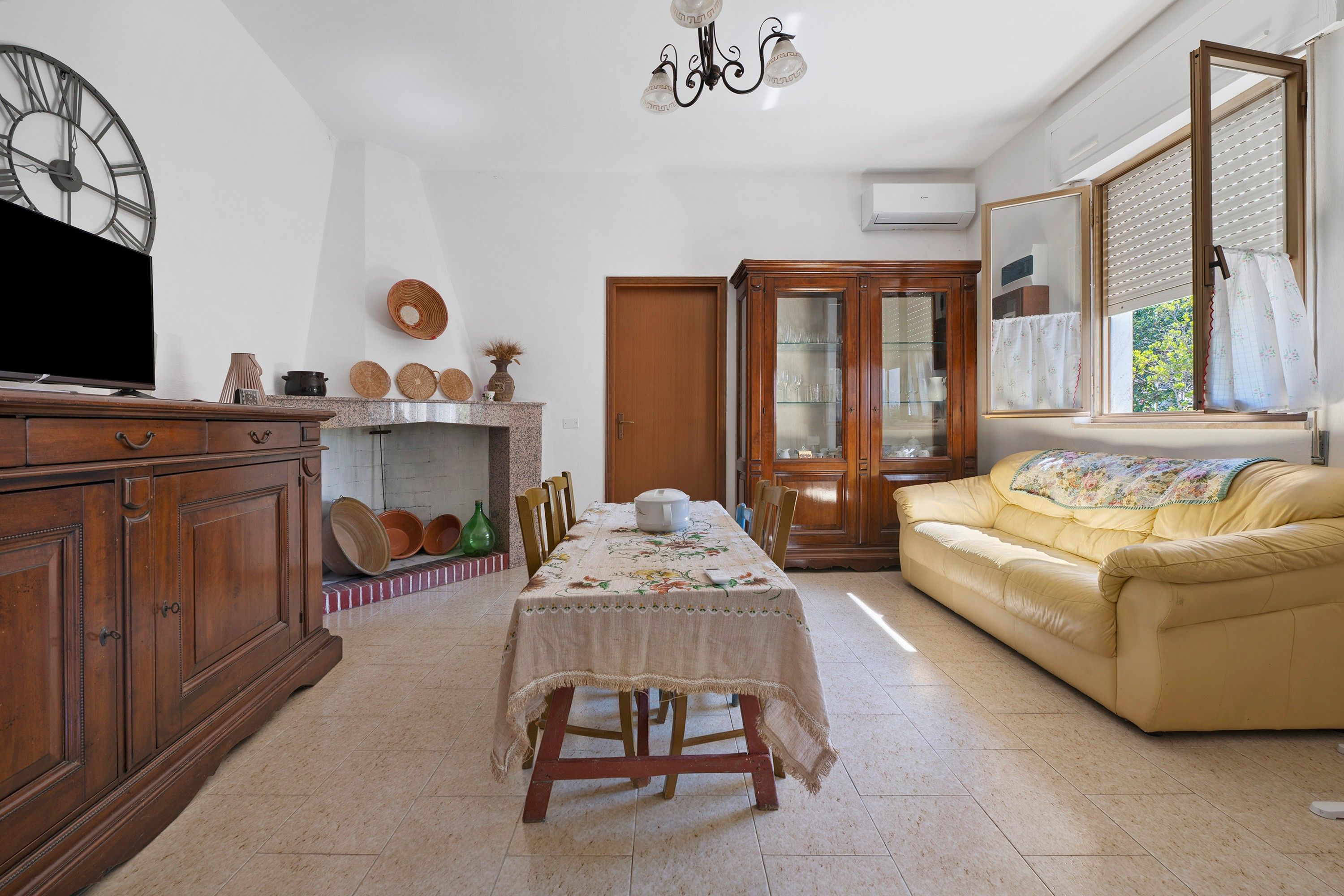 Una sala de estar con televisor, muebles de madera, chimenea y sofá.