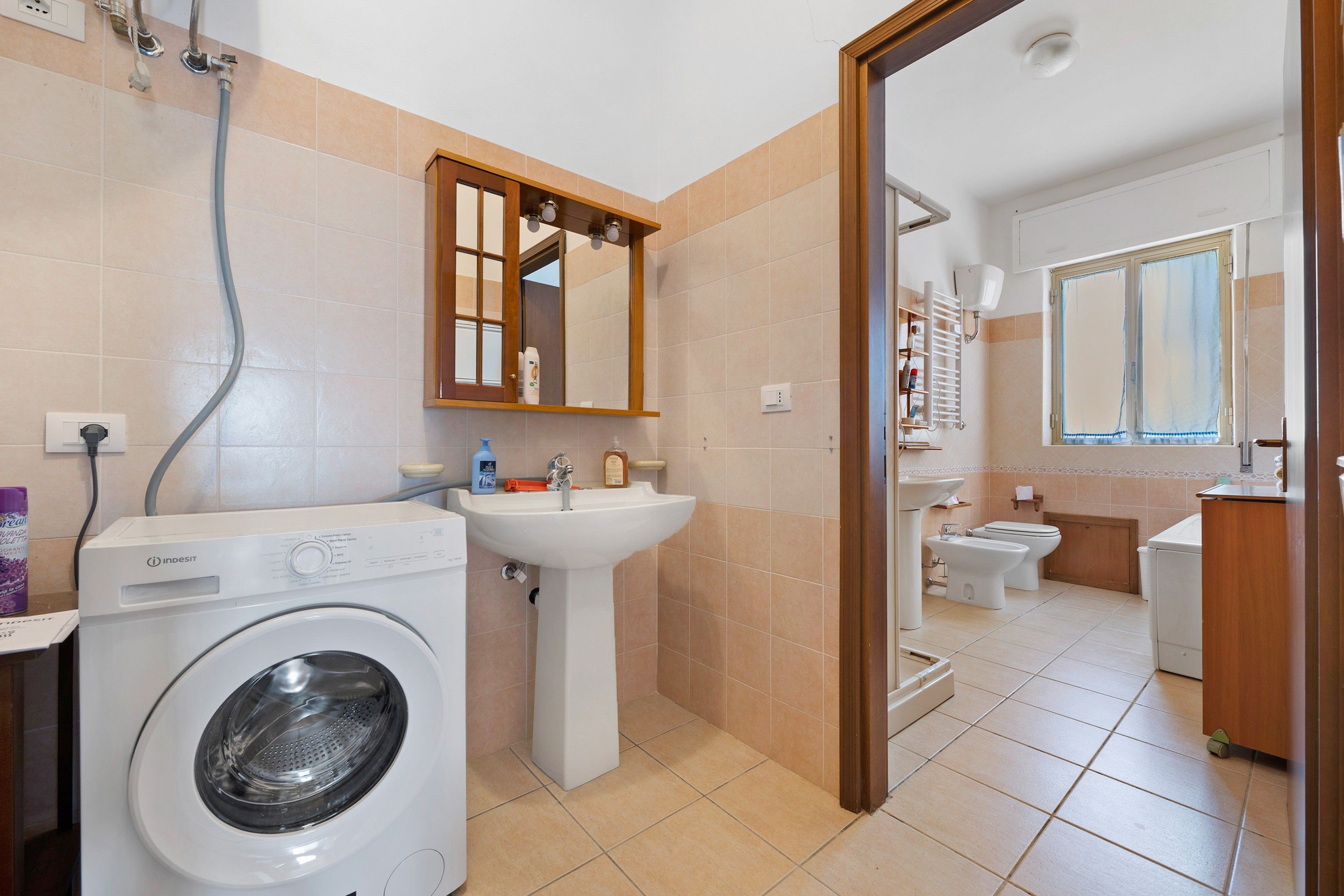 Un bagno moderno con lavatrice, lavandino e bidet.