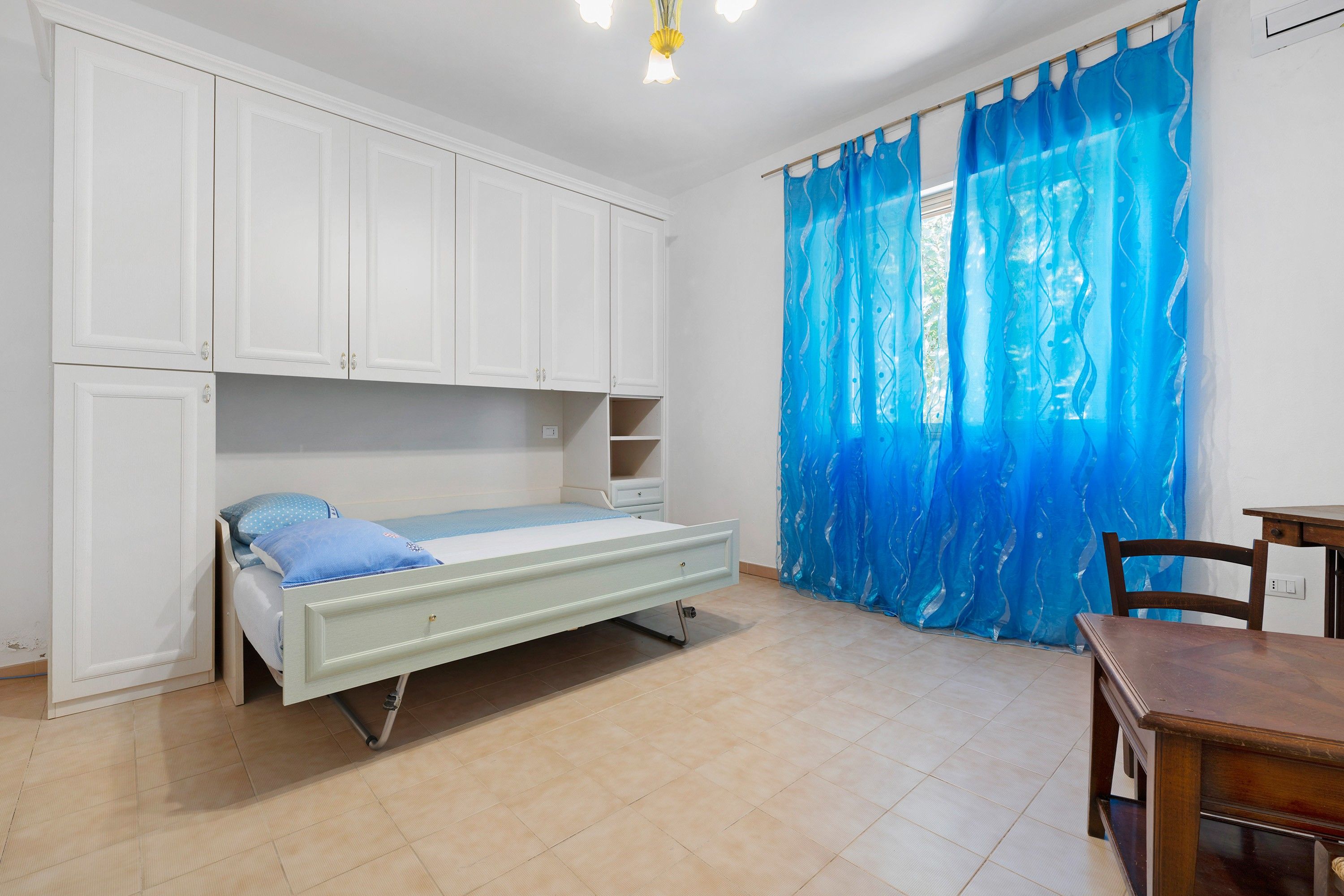 Une chambre à coucher avec un lit, un bureau et une armoire.