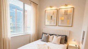 Ein Schlafzimmer mit einem Bett, Nachttischen, einem Deckenventilator und zwei Wandleuchten.
