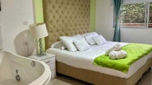 Un dormitorio con una cama, una manta verde y una toalla blanca.