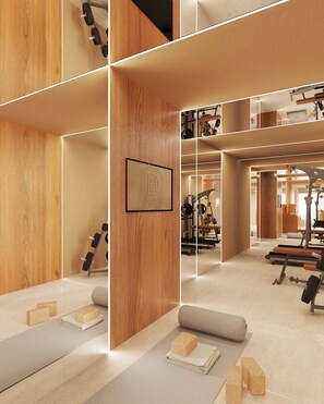 A gym with exercise equipment, wooden walls, and a framed logo.