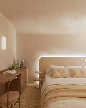 Una camera da letto moderna con una scrivania in legno, una ciotola di mele verdi, una macchina da caffè e un letto con molti cuscini.
