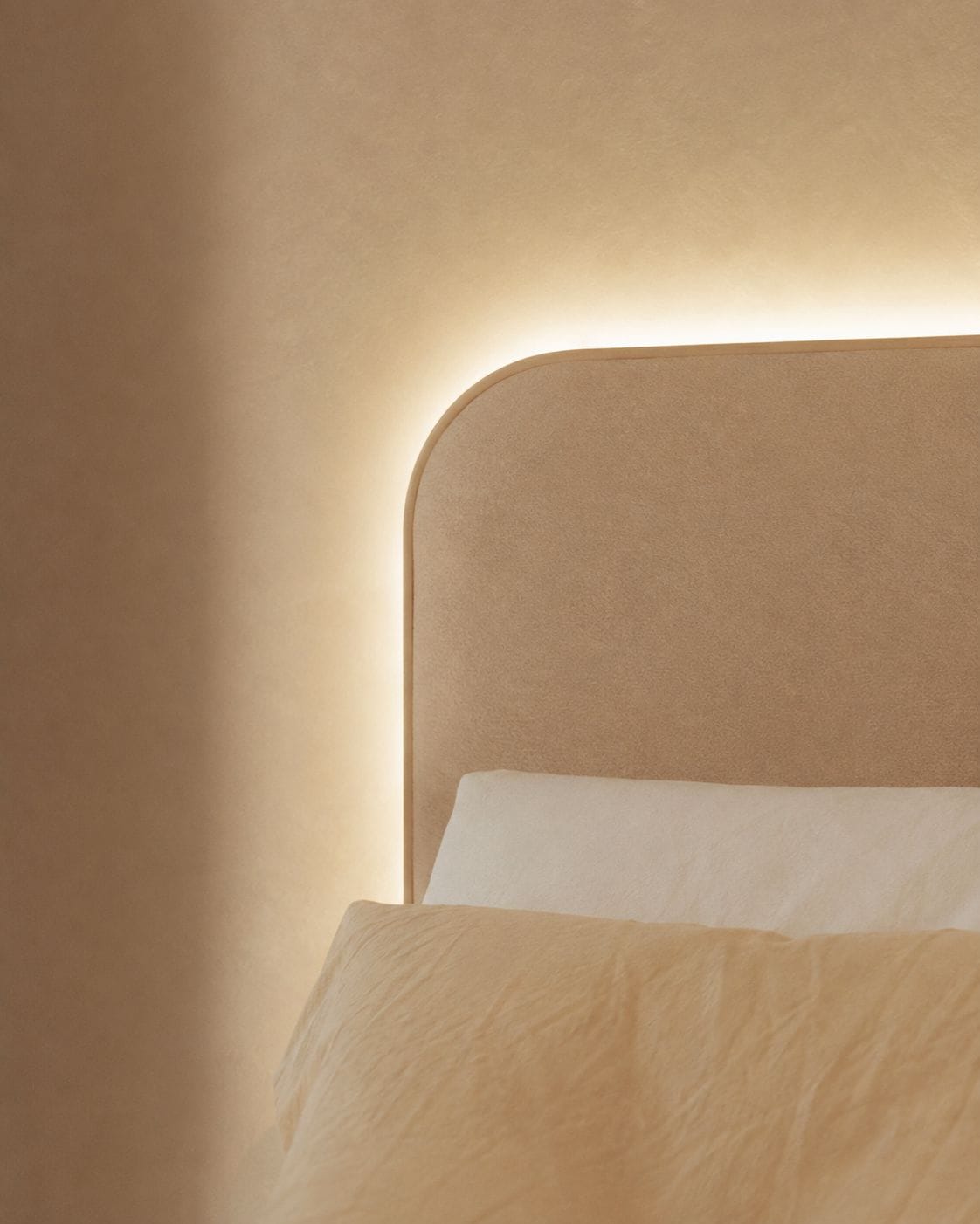 A bed with a headboard and a wall-mounted light fixture.