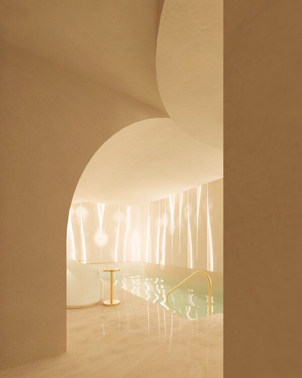 A modern interior with a curved ceiling, a reflective floor, and a minimalist design.