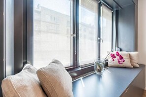 A room with a large window, a bench, and a vase with flowers. - Bright Studio Parliament Free Public Parking near (Budapest)