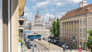 Une vue de rue avec un grand bâtiment doté d’un dôme et de flèches, des voitures, un autobus et un passage piéton.