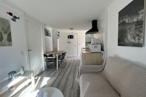 A compact living space with a kitchenette, a dining area, and a sofa. - Casa Gatu 307A by R2R (Cudillero)