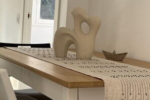 Puinen pöytä, jonka päällä on valkoinen pöytäliina ja koristeellinen maljakko.