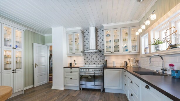 A kitchen with white cabinetry, a stainless steel oven, and a wooden floor. - Historic Executive Residence from 1907 (Telemark)