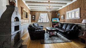 A living room with a fireplace, leather sofas, a coffee table, and a television. - Historic Executive Residence from 1907 (Telemark)