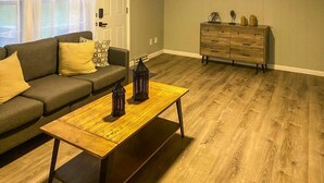 Ein Wohnzimmer mit Couch, Holz-Couchtisch und Kommode.