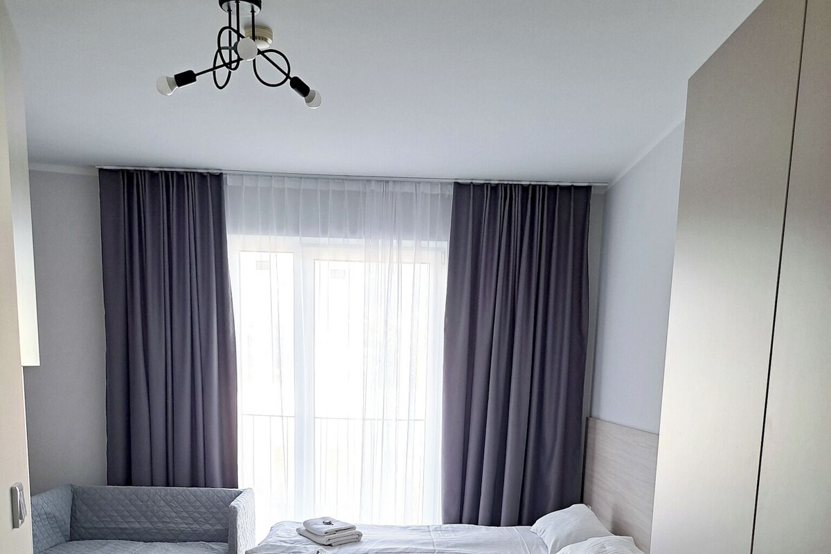 Ein modernes Schlafzimmer mit einem Bett, einer Couch und einem Kleiderschrank.
