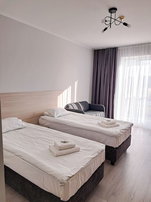 Apartament, 2 llits individuals, cuina bàsica | Escriptori, espai de treball apte per a portàtils i cortines opaques 