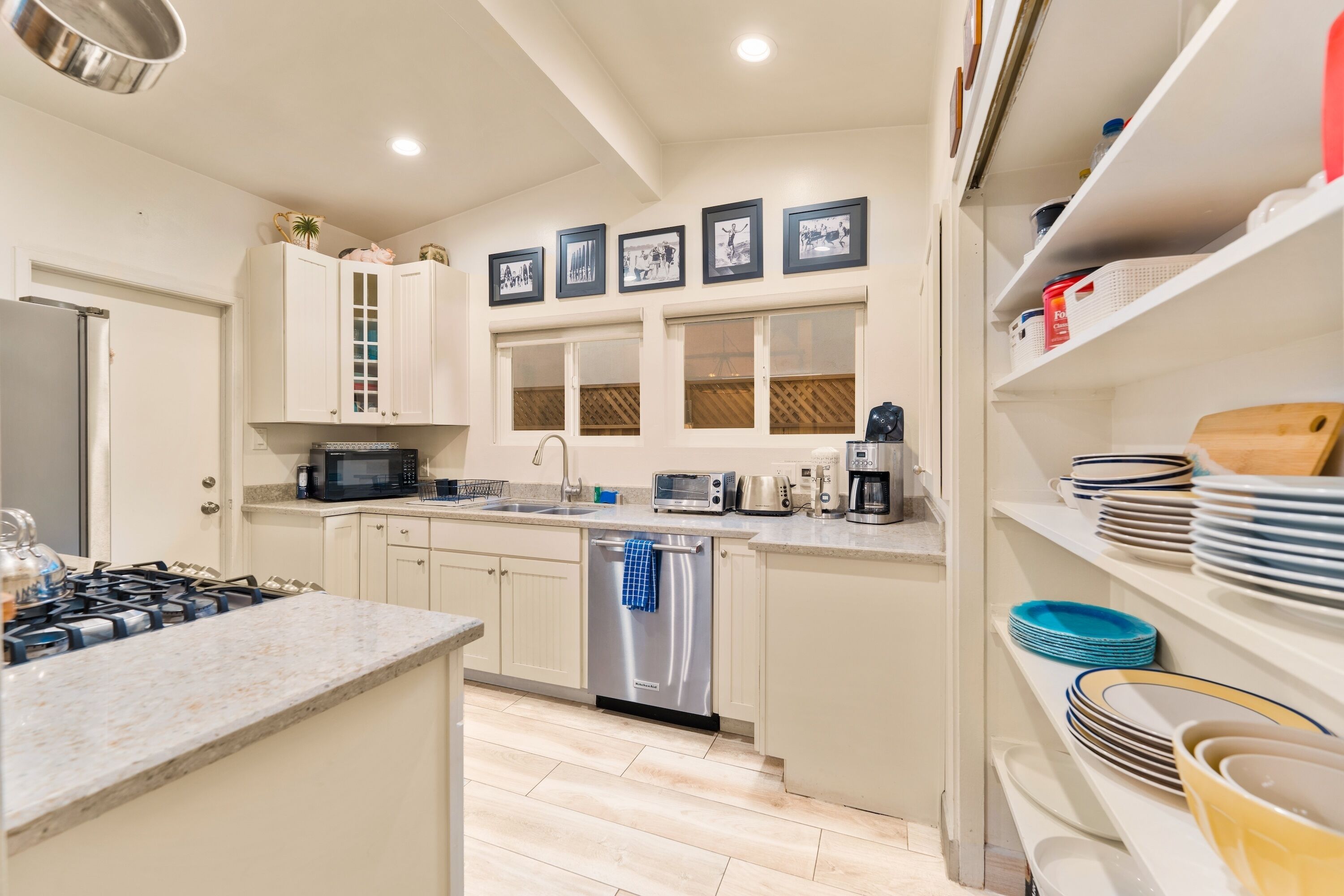 A modern kitchen with white cabinets, stainless steel appliances, and a central island.