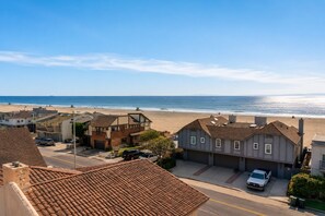 Zona residencial costera con casas, una playa y cielo despejado.